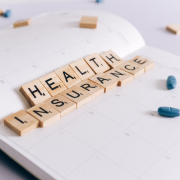 Visual of a notebook with the words "health insurance" spelled out.
